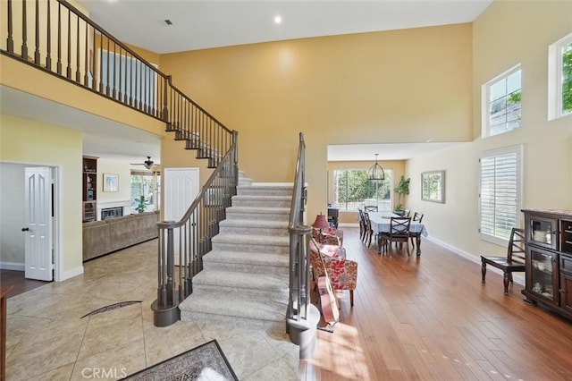 23405 Winslow Pl, Valencia, CA 91354 - stairway with a towering ceiling, plenty of natural light, baseboards, ceiling fan, and wood finished floors
