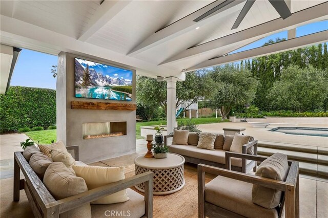 view of patio with an outdoor living space with a fireplace