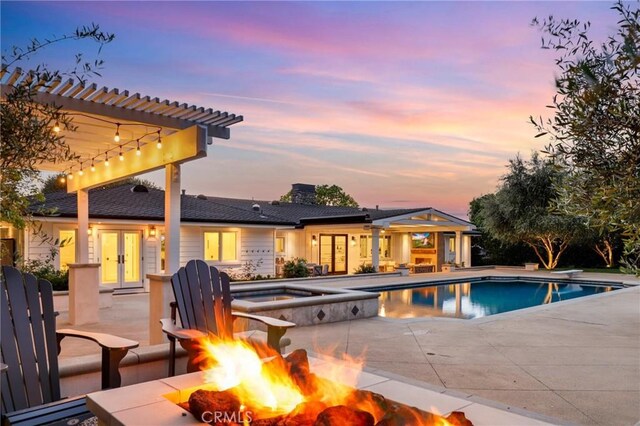 view of swimming pool with a fire pit, french doors, a pergola, a patio area, and a pool with connected hot tub