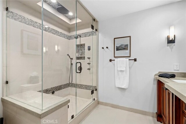 bathroom featuring baseboards, a shower stall, and vanity