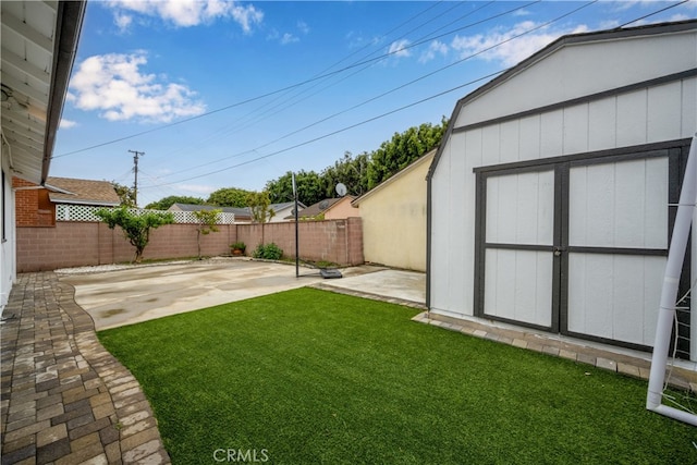view of yard with a patio area, an outdoor structure, and a shed