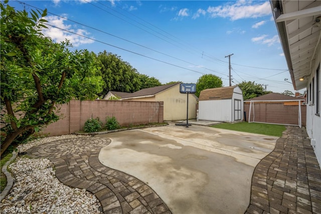 view of patio / terrace featuring a shed, a fenced backyard, and an outdoor structure
