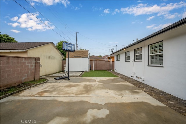 view of patio featuring a fenced backyard, an outbuilding, and a storage shed