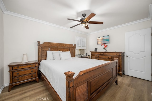 bedroom featuring crown molding, light wood-style flooring, and ceiling fan