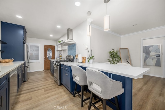 kitchen featuring stainless steel appliances, wall chimney range hood, blue cabinets, open shelves, and a kitchen bar
