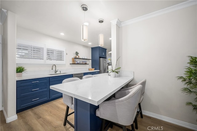 kitchen featuring blue cabinets, a sink, a kitchen breakfast bar, open shelves, and light wood finished floors