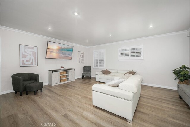 living area with ornamental molding, baseboards, wood finished floors, and recessed lighting