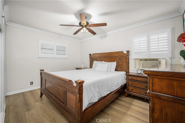 bedroom with wood finished floors, ornamental molding, baseboards, ceiling fan, and cooling unit