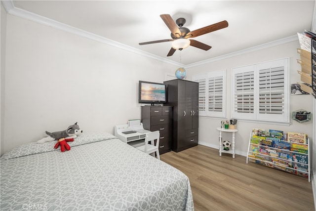 bedroom with wood finished floors, crown molding, baseboards, and a ceiling fan