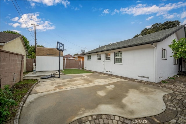 back of property featuring crawl space, a patio, a fenced backyard, and a storage shed
