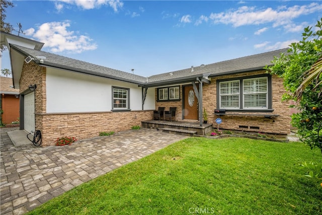 ranch-style home featuring stone siding, stucco siding, an attached garage, and a front yard