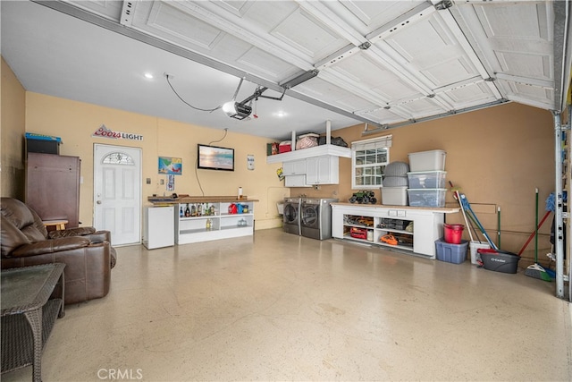 garage with separate washer and dryer and a garage door opener