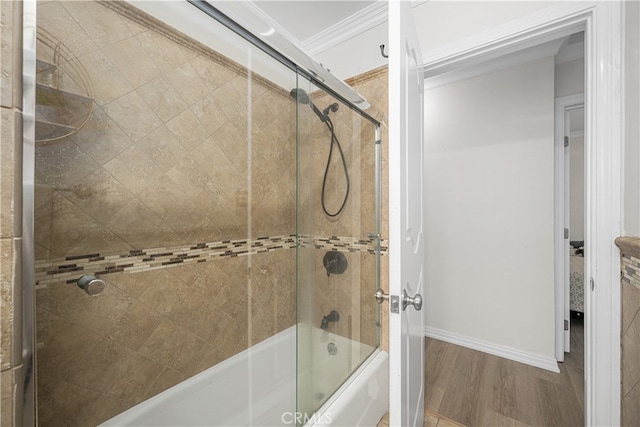 full bathroom featuring wood finished floors, enclosed tub / shower combo, ornamental molding, and baseboards
