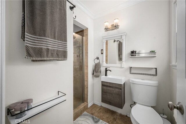 bathroom featuring toilet, ornamental molding, vanity, a tile shower, and tile patterned floors