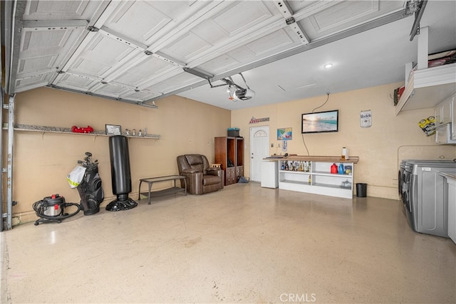 garage with separate washer and dryer and a garage door opener