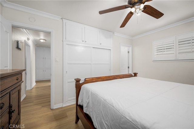 bedroom with ornamental molding, light wood finished floors, a closet, and ceiling fan