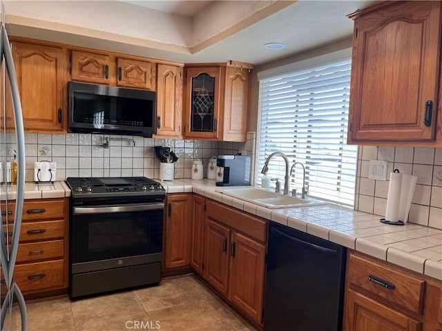 3747 Vista Campana S Unit 7, Oceanside, CA 92057 - kitchen featuring stainless steel appliances, a sink, decorative backsplash, brown cabinets, and light tile patterned flooring