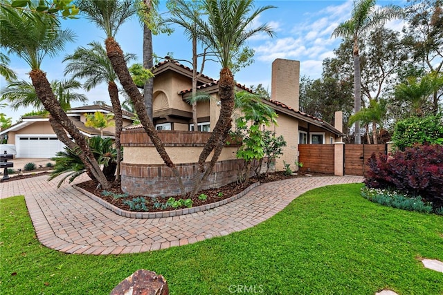 24572 Wembley Cir, Laguna Hills, CA 92653 - view of front of home featuring a chimney, stucco siding, and a gate