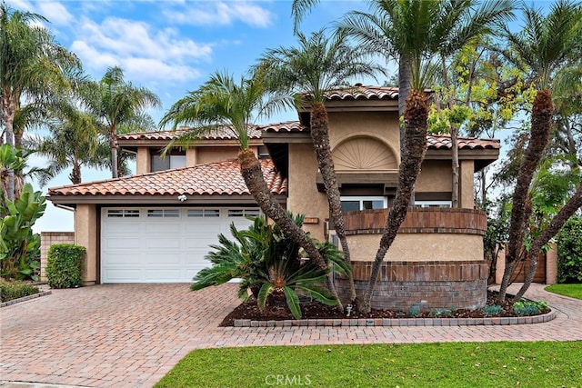 24572 Wembley Cir, Laguna Hills, CA 92653 - mediterranean / spanish-style home with stucco siding, decorative driveway, a garage, and a tile roof