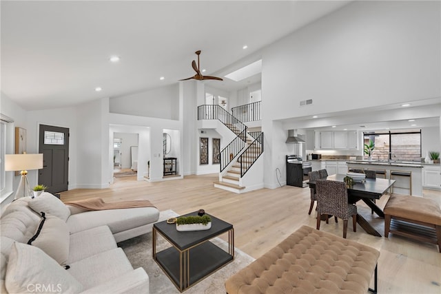 24572 Wembley Cir, Laguna Hills, CA 92653 - living area with high vaulted ceiling, stairway, recessed lighting, light wood finished floors, and baseboards