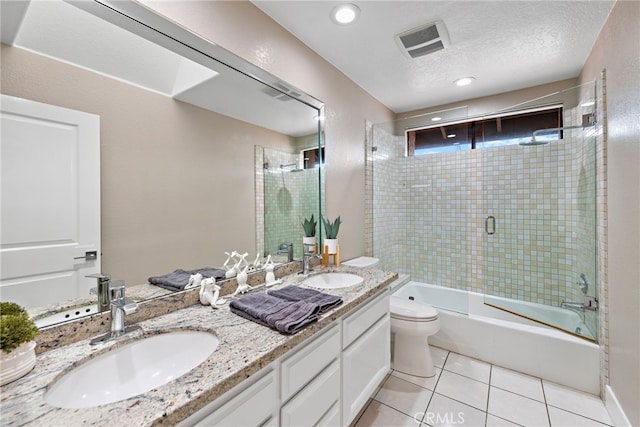 24572 Wembley Cir, Laguna Hills, CA 92653 - full bath featuring toilet, tile patterned floors, bath / shower combo with glass door, double vanity, and a textured ceiling