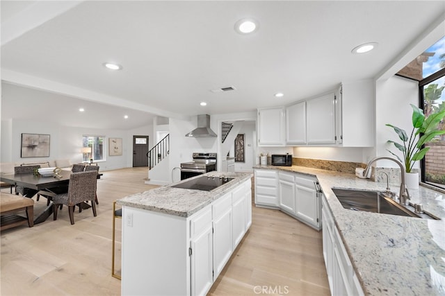 24572 Wembley Cir, Laguna Hills, CA 92653 - kitchen with wall chimney exhaust hood, a kitchen island, a sink, light wood-type flooring, and recessed lighting