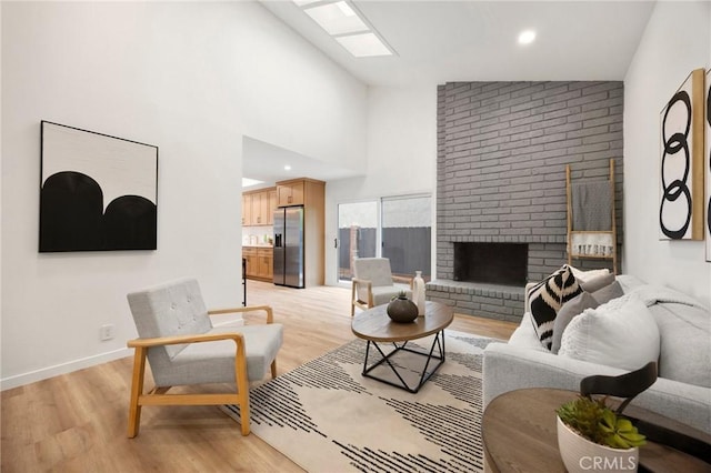 4592 Paloma Ln, Yorba Linda, CA 92886 - living area featuring light wood-style flooring, a skylight, a brick fireplace, baseboards, and high vaulted ceiling