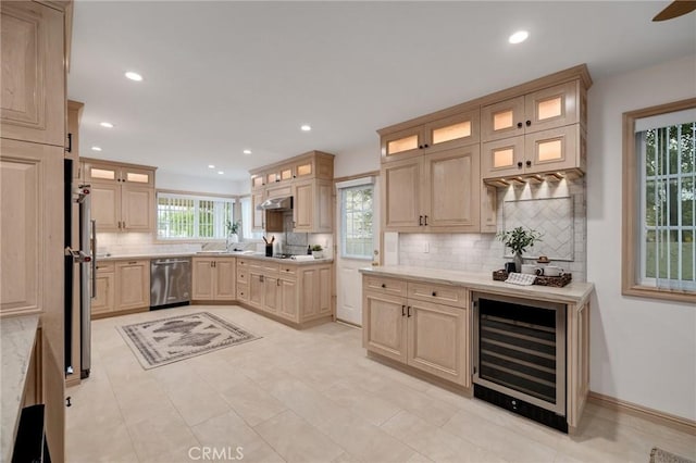 kitchen featuring beverage cooler, stainless steel dishwasher, light countertops, decorative backsplash, and recessed lighting