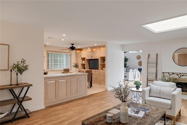 living area with light wood-type flooring, a fireplace, a ceiling fan, and recessed lighting