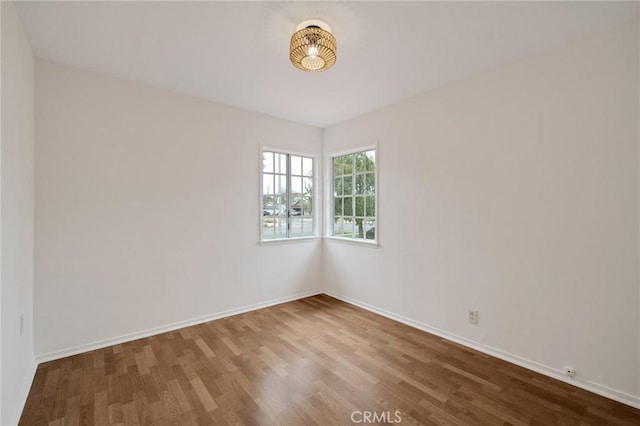 unfurnished room featuring wood finished floors and baseboards