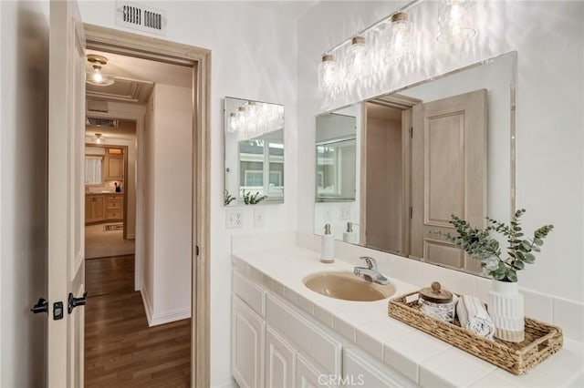 bathroom with wood finished floors, vanity, and baseboards