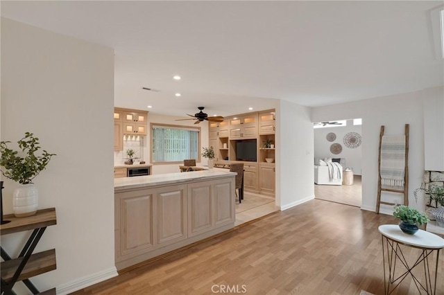 kitchen featuring a ceiling fan, light wood-style floors, glass insert cabinets, recessed lighting, and baseboards