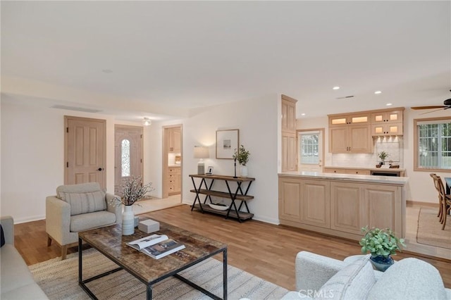living area featuring ceiling fan, light wood-type flooring, baseboards, and recessed lighting