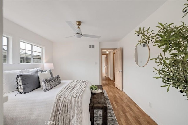 bedroom featuring light wood finished floors, ceiling fan, and baseboards