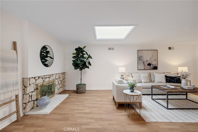 living room with wood finished floors, baseboards, and a fireplace