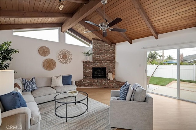 living area featuring wood finished floors, wooden ceiling, a ceiling fan, plenty of natural light, and a fireplace