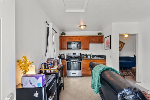 19903 Vanowen St, Winnetka, CA 91306 - kitchen with stainless steel gas stove, black microwave, brown cabinetry, and dark countertops