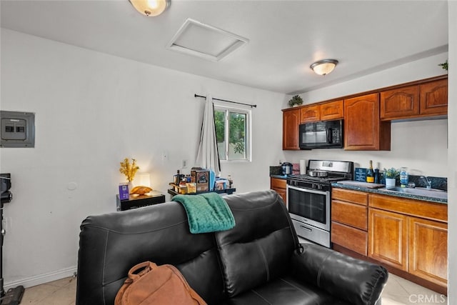 19903 Vanowen St, Winnetka, CA 91306 - kitchen with black microwave, stainless steel gas range, a sink, dark countertops, and brown cabinets