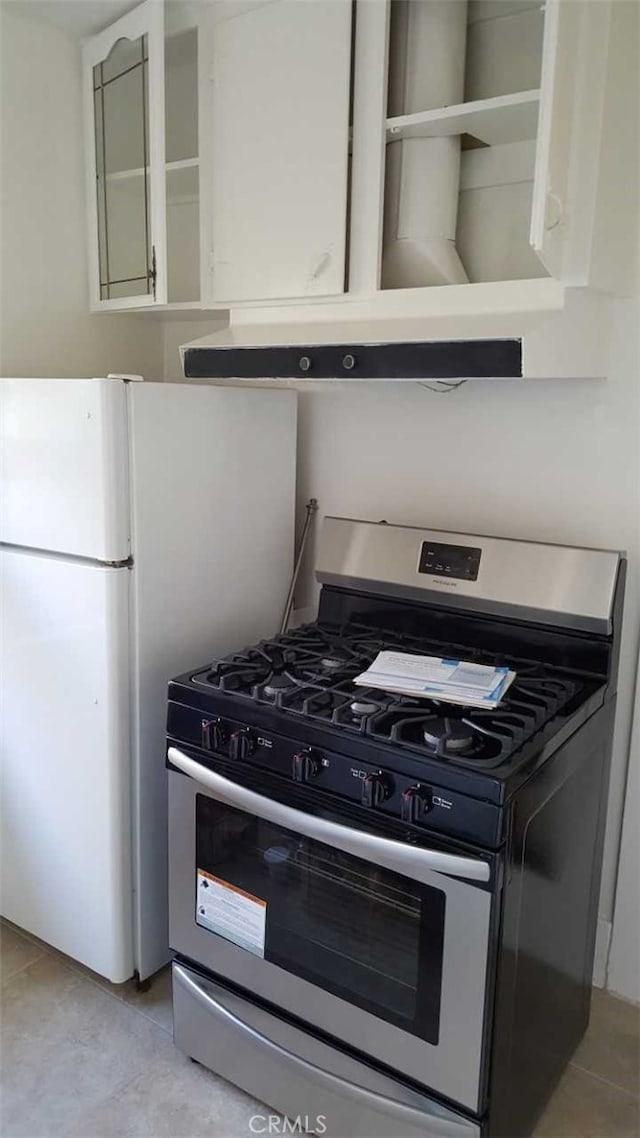 1122 Loma Dr, Hermosa Beach, CA 90254 - kitchen featuring stainless steel range with gas stovetop, light tile patterned floors, under cabinet range hood, open shelves, and freestanding refrigerator