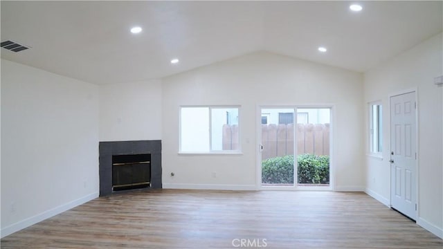 unfurnished living room featuring wood finished floors, a brick fireplace, lofted ceiling, recessed lighting, and baseboards