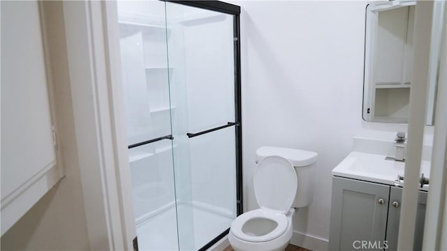 full bath featuring a stall shower, toilet, vanity, and baseboards