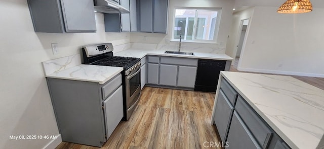 kitchen with gas range, gray cabinetry, black dishwasher, a sink, and under cabinet range hood
