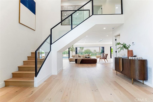 18101 Green Meadow Dr, Encino, CA 91316 - stairway with a towering ceiling, wood finished floors, and baseboards