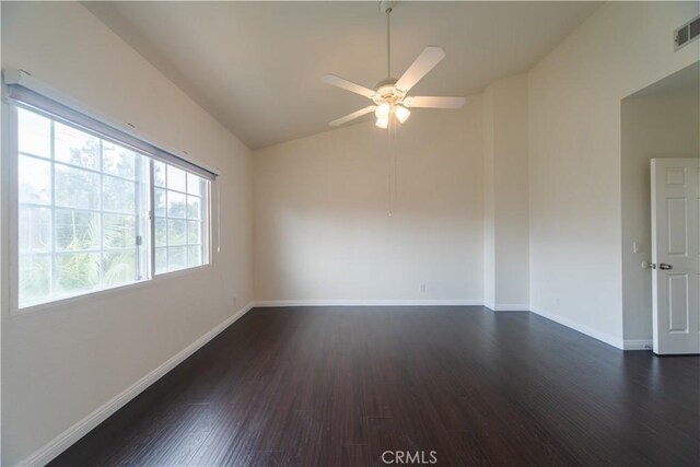 unfurnished room with vaulted ceiling, a ceiling fan, dark wood finished floors, and baseboards