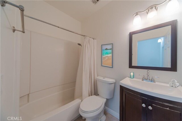 bathroom featuring toilet, vanity, shower / bath combo with shower curtain, and baseboards