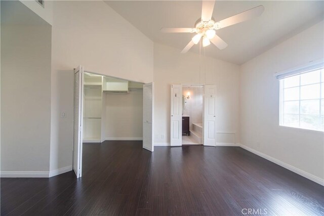 unfurnished bedroom with dark wood-style floors, baseboards, a closet, a ceiling fan, and high vaulted ceiling