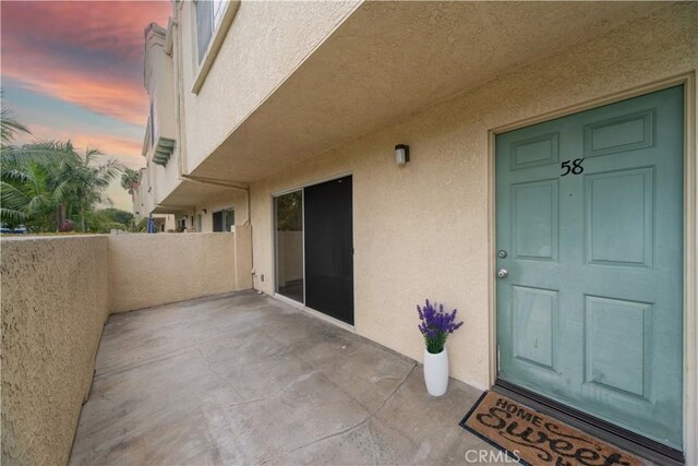 exterior entry at dusk featuring stucco siding