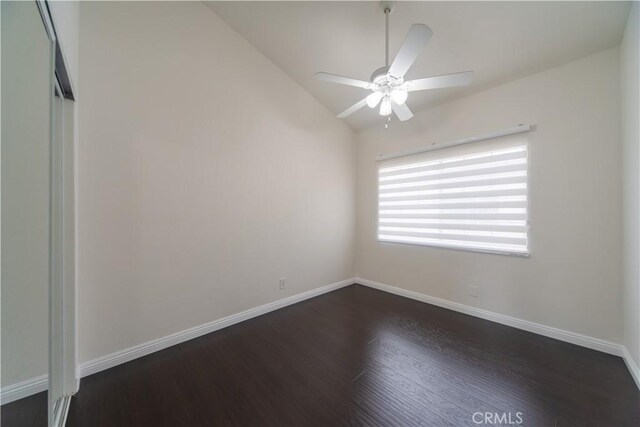 unfurnished room with dark wood-style flooring, a ceiling fan, lofted ceiling, and baseboards