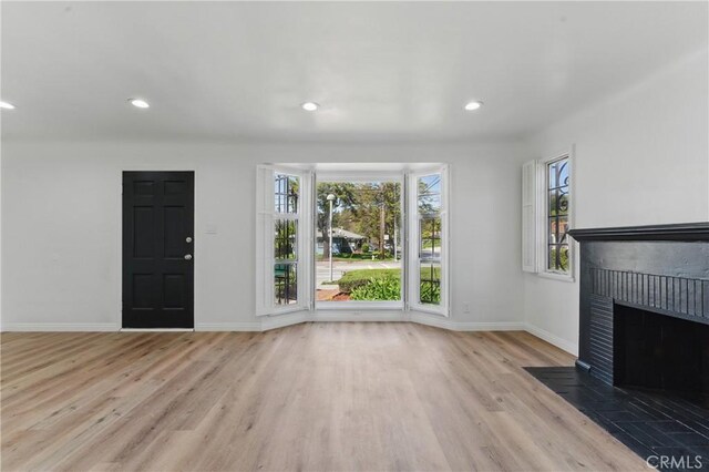 2150 N Eastern Ave, Los Angeles, CA 90032 - unfurnished living room featuring wood finished floors, a brick fireplace, baseboards, and recessed lighting