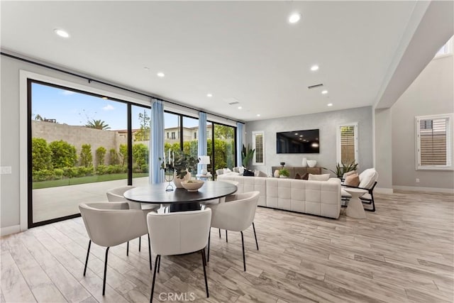 dining space with baseboards, light wood-style floors, and recessed lighting